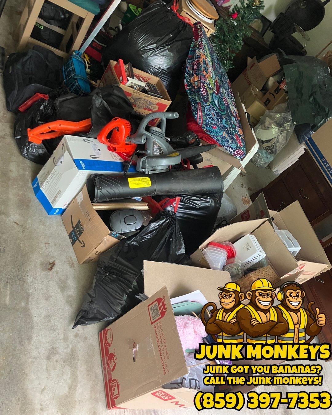 Pile of miscellaneous junk items including boxes, plastic bags, and equipment with Junk Monkeys logo and phone number