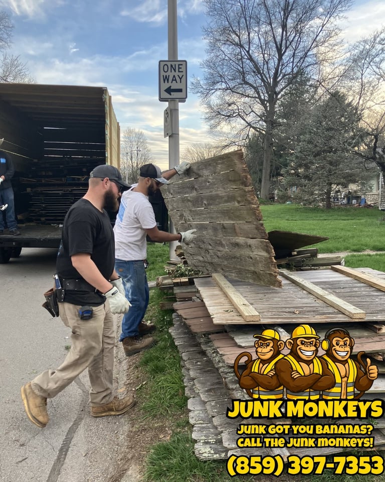 Workers loading junk materials onto a truck; Junk Monkeys logo and phone number displayed at bottom