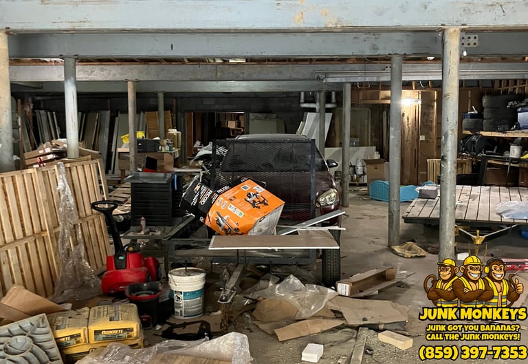 Cluttered auto repair garage interior with car on lift, scattered tools, materials, and equipment on concrete floor